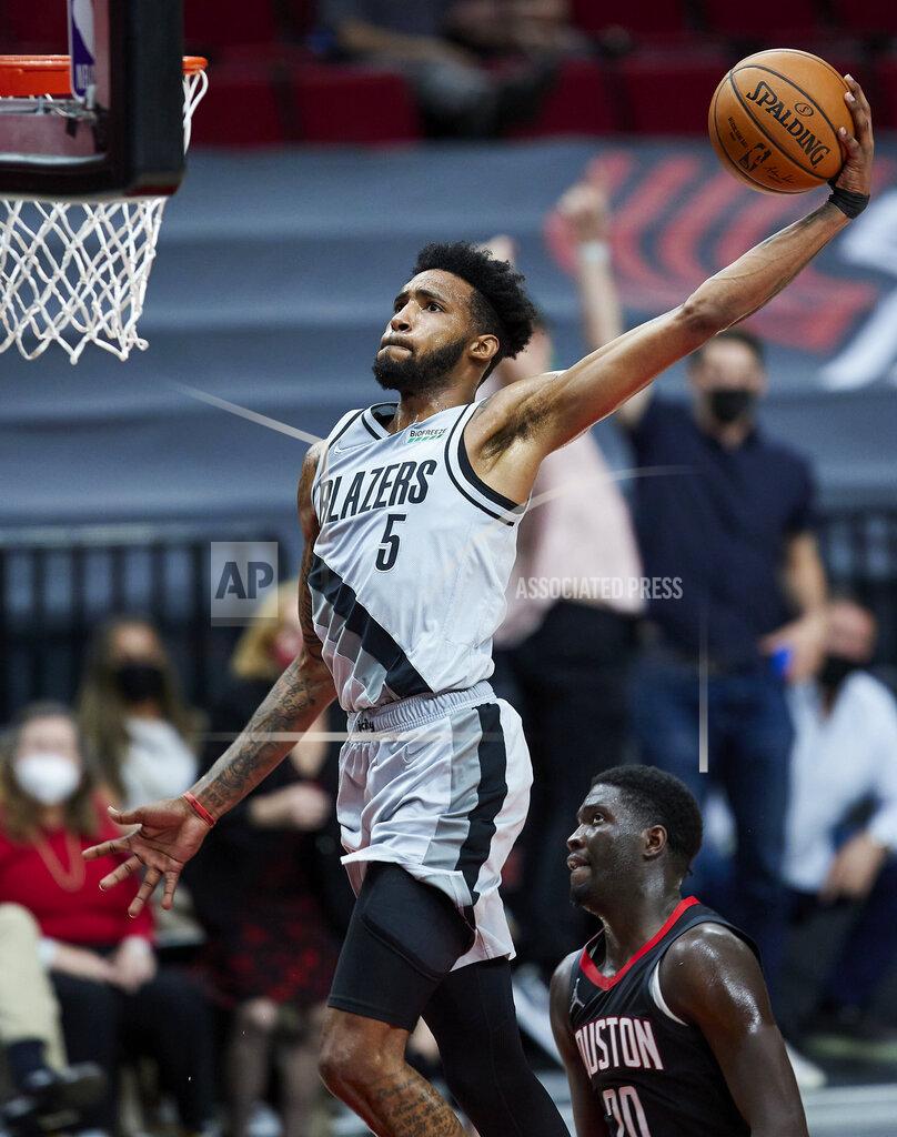 Craig Mitchelldyer Portland Trail Blazers forward Derrick Jones Jr. dunks over Houston Rockets forward Khyri Thomas during the second half of an NBA basketball game in Portland, Ore., Monday, May 10, 2021. (AP Photo/Craig Mitchelldyer)