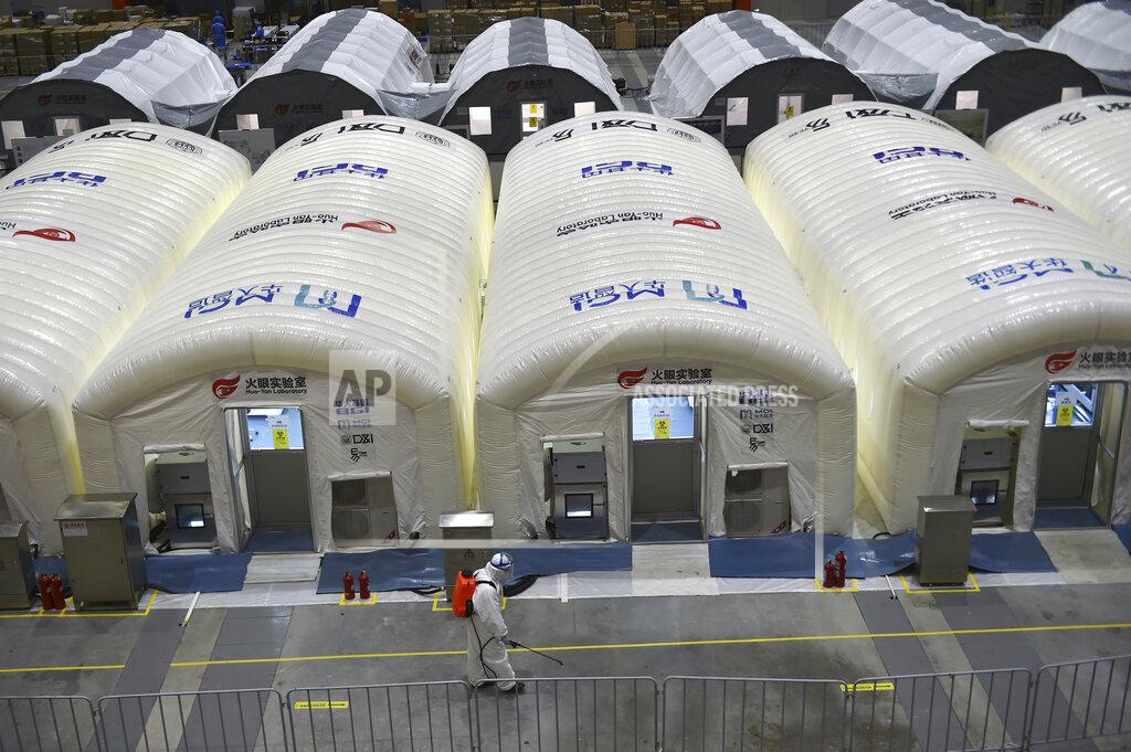 Uncredited A worker disinfects the flooring outside the inflated cabins at the pop-up Huo-Yan Laboratory set up in an expo center to test samples for covid-19 virus in Nanjing in east China's Jiangsu province Wednesday, July 28, 2021. China's worst coronavirus outbreak since the start of the pandemic a year and a half ago escalated Wednesday, Aug. 4, 2021, with dozens more cases around the country, the sealing-off of one city and the punishment of its local leaders. (Chinatopix Via AP)