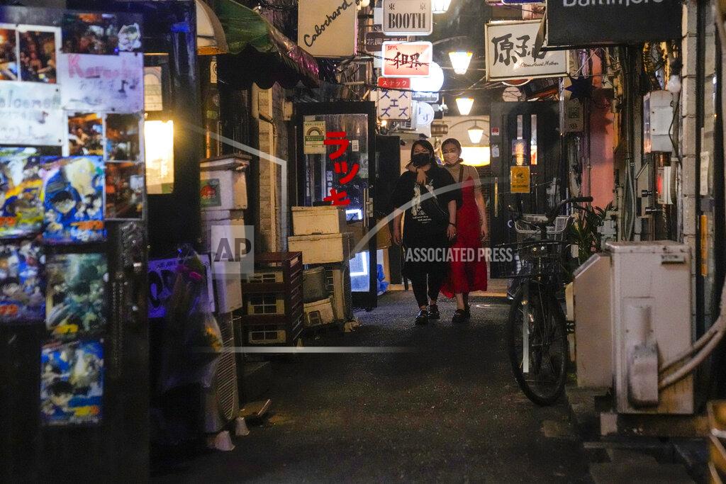 Kiichiro Sato People walk around and gather at a bar after government imposed 8 p.m. closing time for restaurants and bars under Tokyo's fourth state of emergency Saturday, July 17, 2021, in Tokyo. The latest state of emergency has asked restaurants and bars to close by 8 p.m., if not entirely. This has pushed people to drink outside, although many bars remain open and bustling with customers who are defying the rules and expressing frustration and indifference. (AP Photo/Kiichiro Sato)