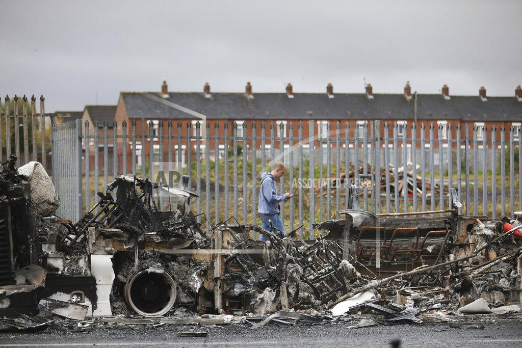 Peter Morrison FILE - In this Thursday, April 8, 2021 file photo, a man walks past a burnt out bus on the Shankill road in West Belfast, Northern Ireland. The chaotic scenes during a week of violence on the streets of Northern Ireland have stirred memories of decades of Catholic-Protestant conflict, known as “The Troubles.” A 1998 peace deal ended large-scale violence but did not resolve Northern Ireland’s deep-rooted tensions. (AP Photo/Peter Morrison, File)