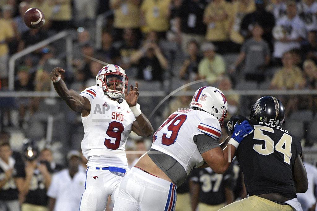 Phelan M. Ebenhack SMU quarterback William Brown (9) throws a pass as offensive lineman Larry Hughes (79) blocks Central Florida defensive lineman A.J. Wooten (54) during the first half of an NCAA college football game Saturday, Oct. 6, 2018, in Orlando, Fla. (AP Photo/Phelan M. Ebenhack)