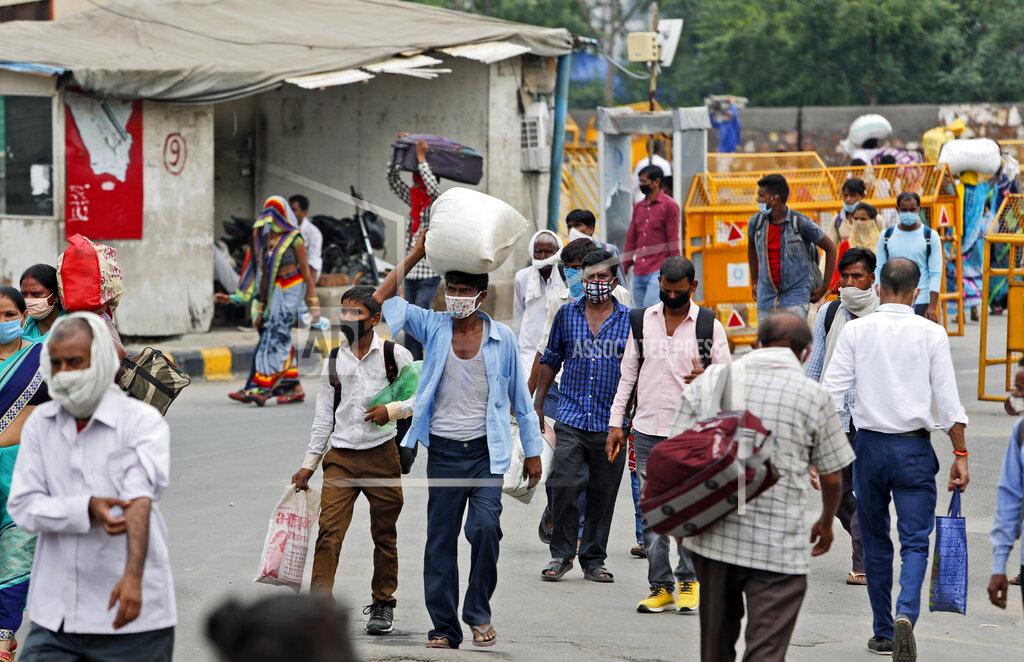 Manish Swarup Migrant workers return with their belongings to look for work in New Delhi, India, Tuesday, Aug. 18, 2020. The lockdown imposed in late March cost more than 10 million impoverished migrant workers their jobs in the cities. Many made grueling journeys back to their hometowns and villages. Now they face the ordeal of trying to get back to their factory jobs. The government began easing a stringent two-month-long lockdown in June, but business is only a quarter to a fifth of usual and customers are scarce, said Praveen Khandelwal, general secretary of the Confederation of All India Traders. (AP Photo/Manish Swarup)