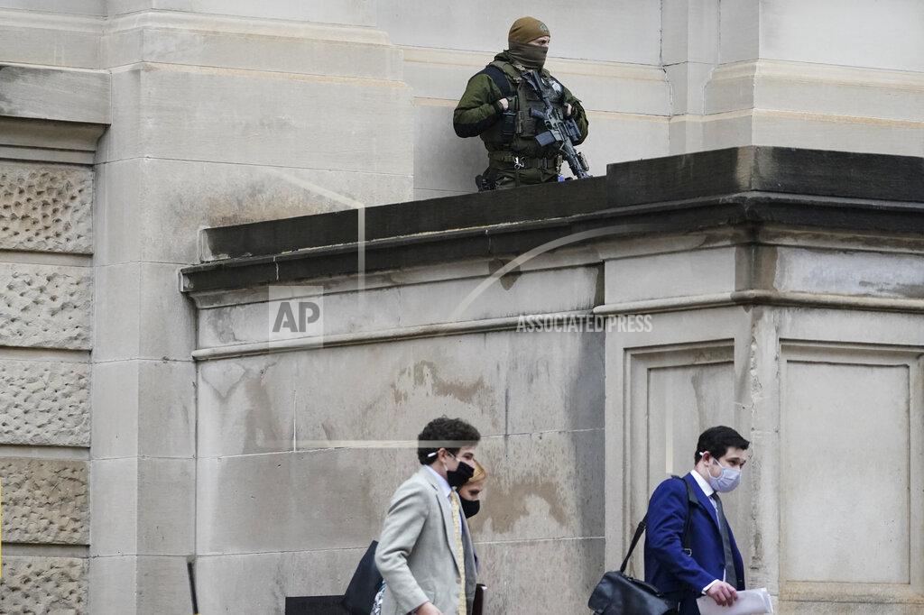 Brynn Anderson A member of the Georgia State Patrol SWAT team looks on as people walk by outside of the Georgia State capitol after the opening day of the legislative session on Monday, Jan. 11, 2021, in Atlanta. State capitols across the country are under heightened security after the siege of the U.S. Capitol last week. (AP Photo/Brynn Anderson)