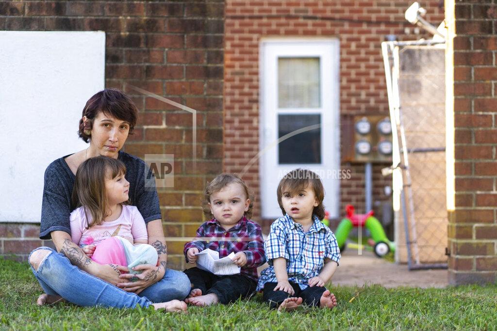 Kandise Norris, shown here with her three children in a Nov. 7 photo outside their home in Somerset County, Maryland, says she has been rebuilding her life since getting treatment for drug addiction in April 2019. The Housing Authority of Crisfield, Maryland, which owns her house, has filed three eviction cases against the 30-year-old since September. (Nick McMillan/Howard Center for Investigative Journalism via AP)