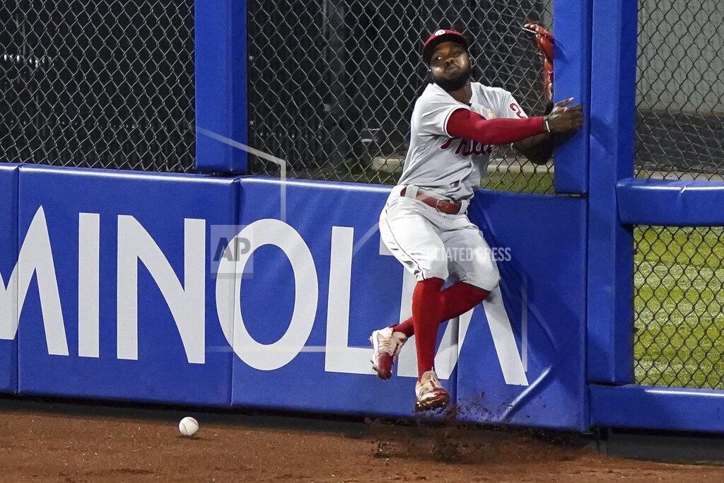 John Minchillo Philadelphia Phillies center fielder Roman Quinn collides with the outfield wall after he missed an RBI double hit by New York Mets' Robinson Chirinos during the sixth inning of a baseball game Saturday, Sept. 5, 2020, in New York. (AP Photo/John Minchillo)