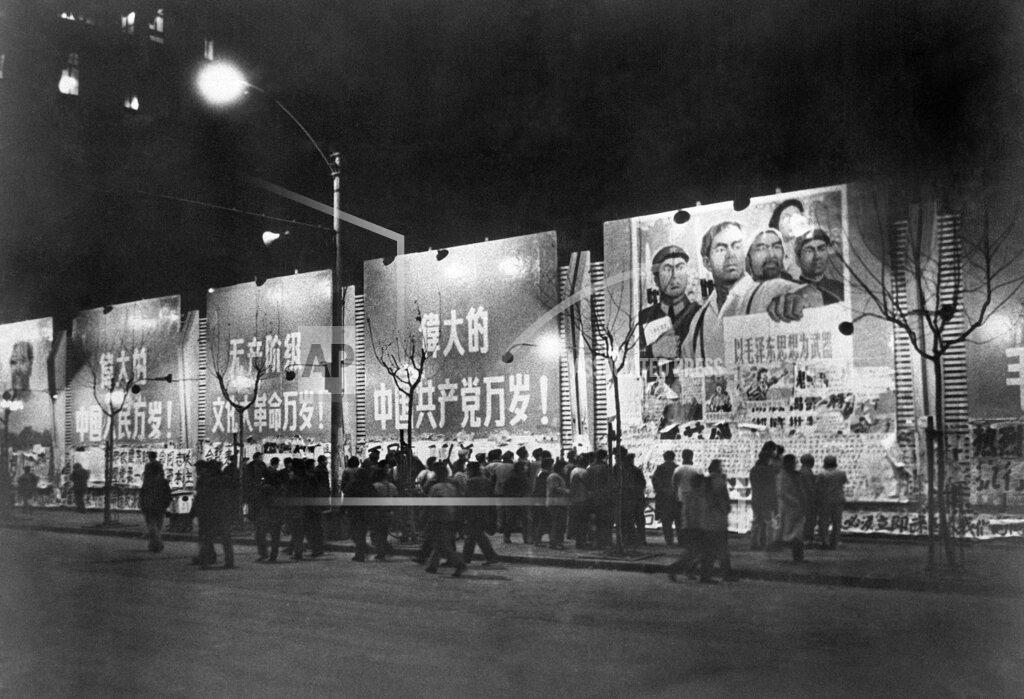 Uncredited FILE - In this Jan. 6. 1967 file photo, citizens crowd in front of illuminated bulletin boards to read newspapers on a wall along Nanking street in Shanghai, China. Posters above read, "Long Live the Cultural Revolution, Long Live the Chinese People, Long Live the Great Chinese Communist Party." Chairman Mao's Cultural Revolution from the mid-1960s caused the deaths of up to two million people and affected all parts of society. It was seen as an attack to rid the country of his enemies which subsequent leaders described as a catastrophe period that set the nation back years. (AP Photo)
