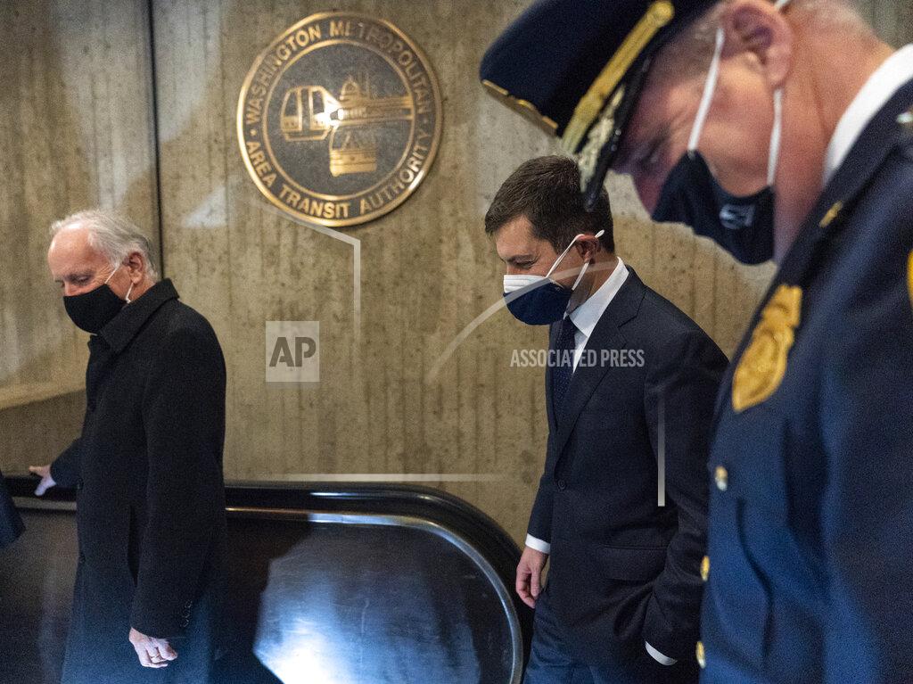 Carolyn Kaster Transportation Secretary Pete Buttigieg, second from left, walks to an escalator as he leaves Union Station after speaking in Washington, Friday, Feb. 5, 2021. (AP Photo/Carolyn Kaster)