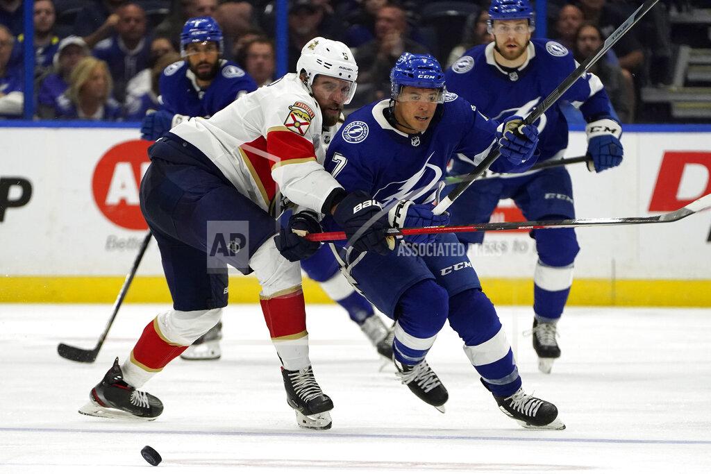 Chris O'MEara Tampa Bay Lightning right wing Mathieu Joseph (7) dumps the puck past Florida Panthers defenseman Aaron Ekblad (5) during the second period of an NHL hockey game Tuesday, Oct. 19, 2021, in Tampa, Fla. (AP Photo/Chris O'Meara)