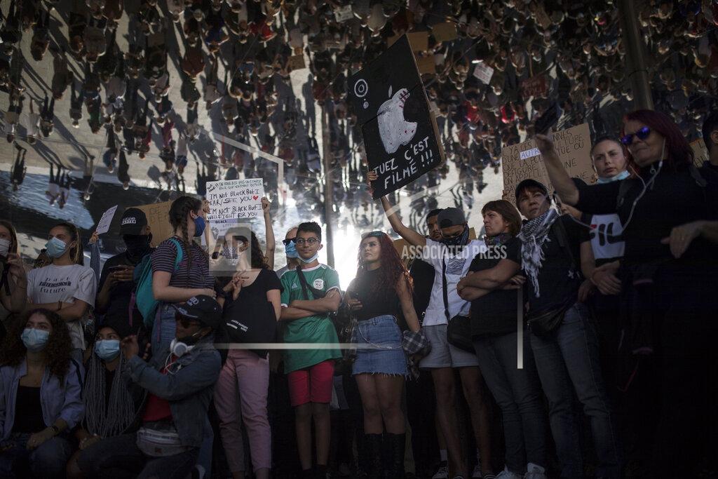 A protester holds a sign that reads "kill, it is being filmed" in Marseille, southern France, Saturday, June 6, 2020, to protest against the death of George Floyd, who died after he was restrained by police officers May 25 in Minneapolis, that has led to global protests. (AP Photo/Daniel Cole)