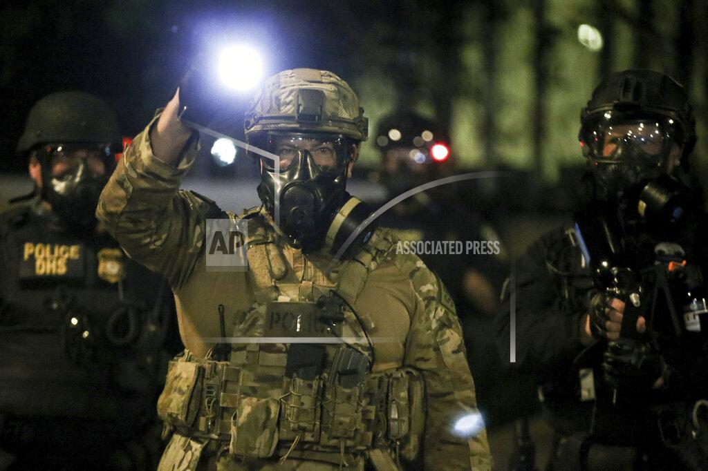 Dave Killen Police respond to protesters during a demonstration, Friday, July 17, 2020 in Portland, Ore. Militarized federal agents deployed by the president to Portland, fired tear gas against protesters again overnight as the city’s mayor demanded that the agents be removed and as the state’s attorney general vowed to seek a restraining order against them.(Dave Killen/The Oregonian via AP)