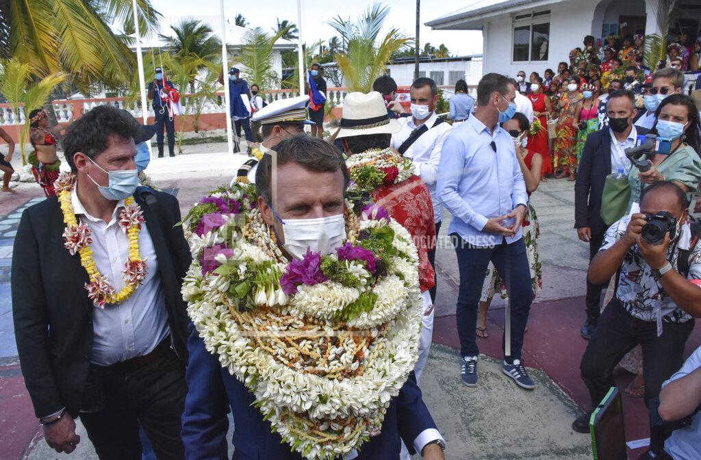 Esther Cuneo France's President Emmanuel Macron wears a flowers leis and seashell necklaces as he arrived at the Manihi Atoll, 500 kms (312 mls) north east of Tahiti, French Polynesia in the Pacific Ocean, Monday, July 26, 2021. On Friday, July 30, The Associated Press reported on stories circulating online incorrectly claiming a video shows Macron becoming a “human wreath” during his official welcome to French Polynesia, when in fact the video was manipulated to add additional leis. (AP Photo/Esther Cuneo, File)