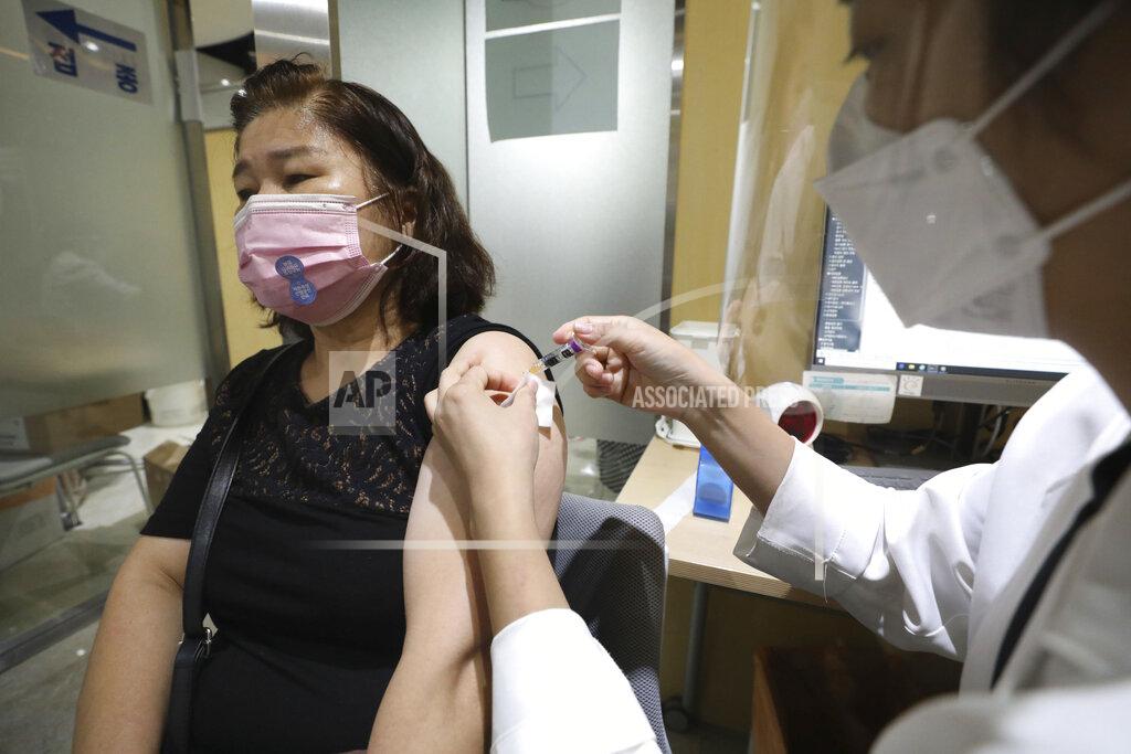 Hong Hyo-Shick A woman wearing a face mask gets a flu shot at the Korea Association of Health Promotion in Seoul, South Korea, Thursday, Oct. 22, 2020. The steady spread of the coronavirus caused concern in a country that eased its social distancing restrictions just last week to cope with a weak economy. (Hong Hyo-shick/Newsis via AP)