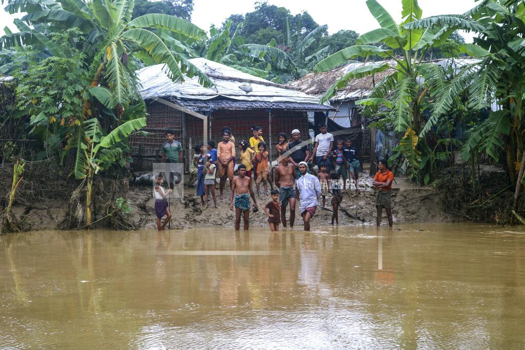 Shafiqur Rahman Rohingya refugees look at flood water following heavy rains at the Rohingya refugee camp in Kutupalong, Bangladesh, Wednesday, July 28, 2021. Days of heavy rains have brought thousands of shelters in various Rohingya refugee camps in Southern Bangladesh under water, rendering thousands of refugees homeless. (AP Photo/ Shafiqur Rahman)