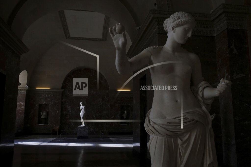 Thibault Camus The Venus of Milo sculpture, background, is lit by a ray of light in the Louvre museum, in Paris, Thursday, Feb. 11, 2021. It's uncertain when the Louvre will reopen, after being closed on Oct. 30 in line with the French government's virus containment measures. But those lucky enough to get in benefit from a rarified private look of collections covering 9,000 years of human history -- with plenty of space to breathe. (AP Photo/Thibault Camus)