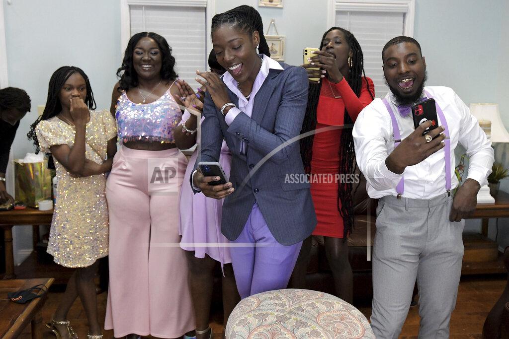 Bob Self Rennia Davis, center, celebrates with family and friends after the Minnesota Lynx selected her with the ninth pick in the WNBA basketball draft, Thursday, April 15, 2021, in Jacksonville, Fla. (Bob Self/The Florida Times-Union via AP)