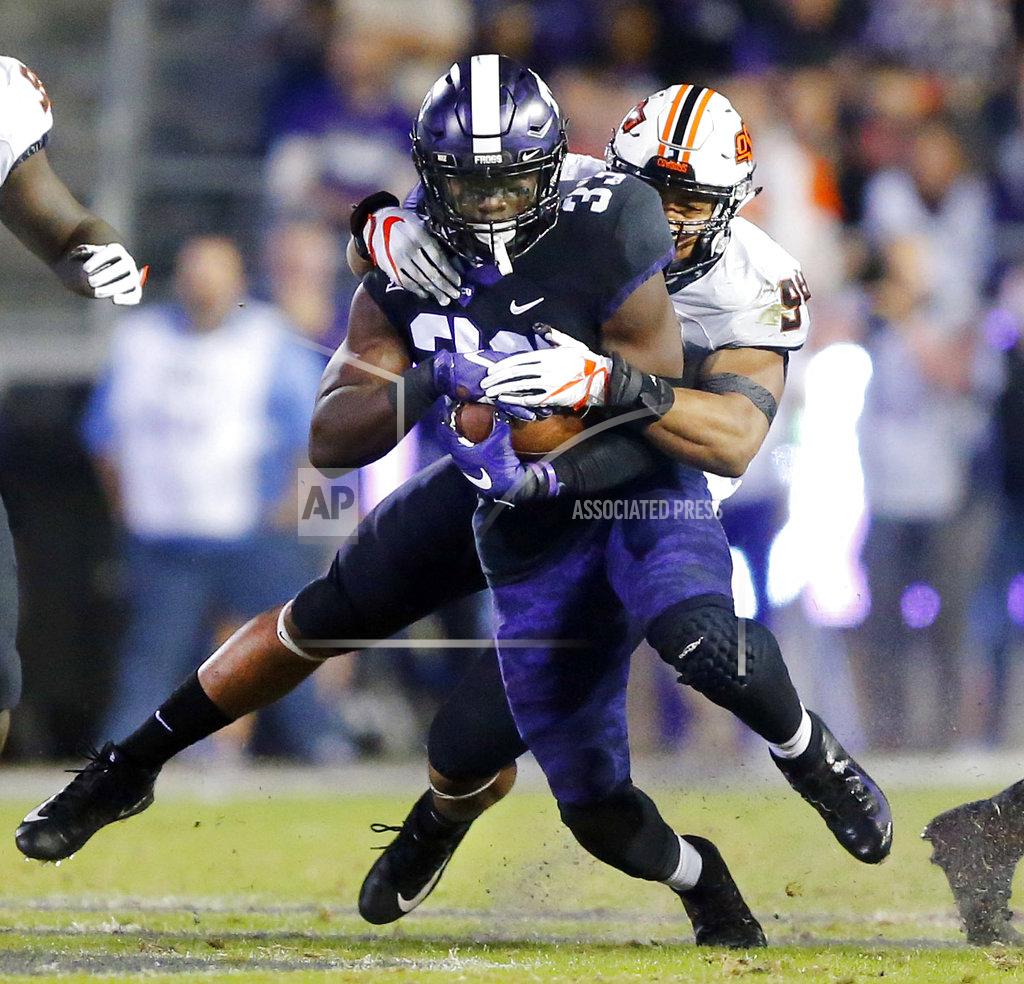 Tom Fox Oklahoma State defensive end Jordan Brailford (94) makes a diving tackle of TCU running back Sewo Olonilua (33) during the second quarter of an NCAA college football game in Fort Worth, Texas, Saturday, Nov. 24, 2018. (Tom Fox/The Dallas Morning News via AP)