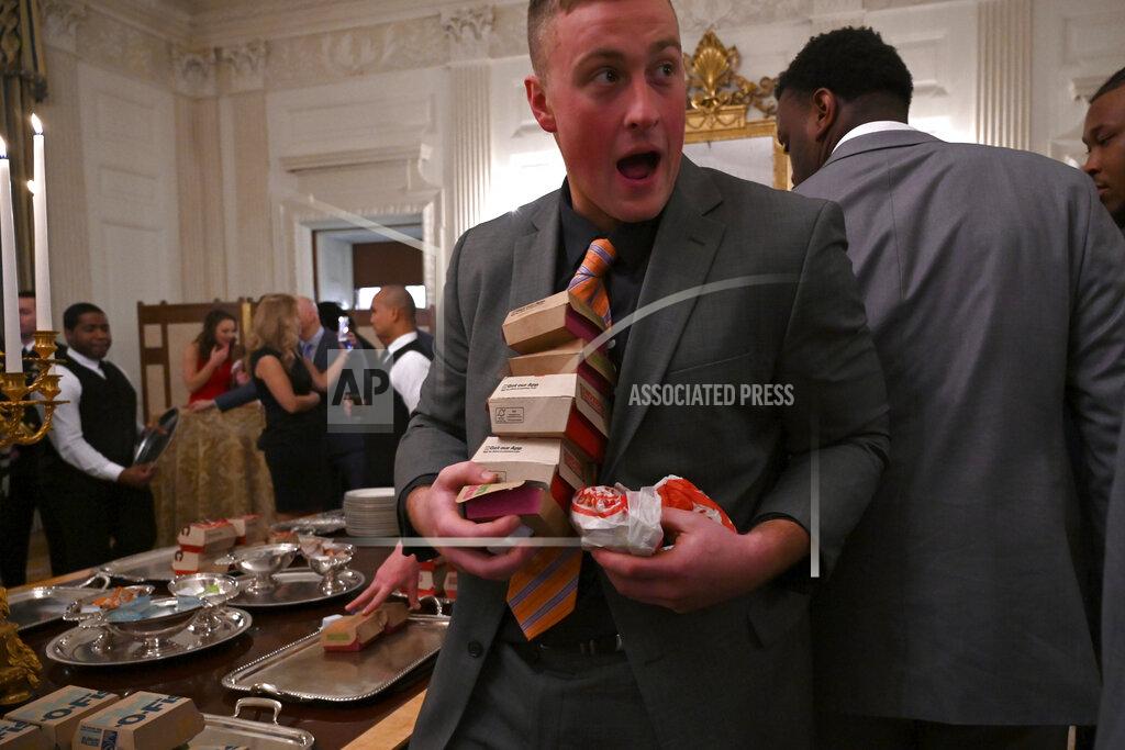 Susan Walsh Guests attending a reception for the Clemson Tigers grab fast food sandwiches in the State Dining Room of the White House in Washington, Monday, Jan. 14, 2019. (AP Photo/Susan Walsh)