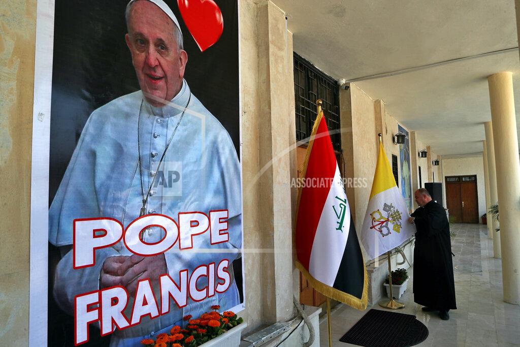 Khalid Mohammed Father Nazeer Dako arranges a Vatican flag to welcome Pope Francis at St. Joseph's Chaldean Church ahead of the Pope's visit, in Baghdad, Iraq, Tuesday, March 2, 2021. (AP/Photo/Khalid Mohammed)