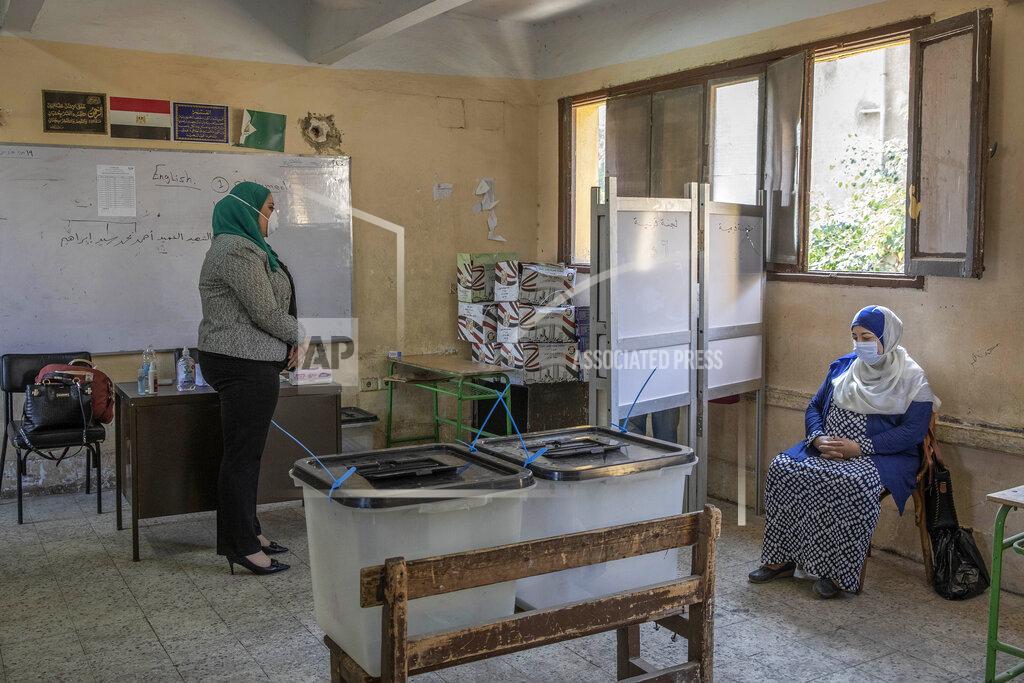 Nariman El-Mofty Election workers wait for a man to cast his vote on the first day of the Senate elections inside a polling station in Cairo, Egypt, Tuesday, Aug. 11, 2020. Egyptians started voting on Tuesday for the Senate, the upper chamber of parliament that was revived as part of constitutional amendments approved in a referendum last year, an election that comes as the country faces an uptick in daily numbers of new coronavirus cases. (AP Photo/Nariman El-Mofty)