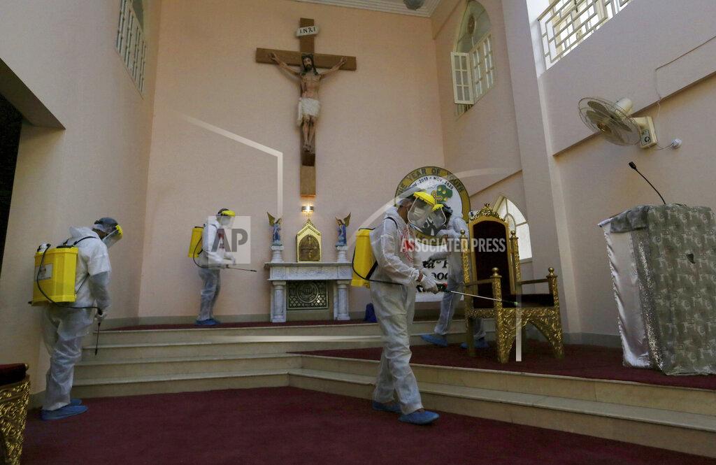 Fareed Khan Volunteers spray disinfectant in the main hall of St Paul's Parish in an effort to curb the spread of the coronavirus, ahead of Christmas celebrations, in Karachi, Pakistan, Tuesday, Dec. 22, 2020. (AP Photo/Fareed Khan)