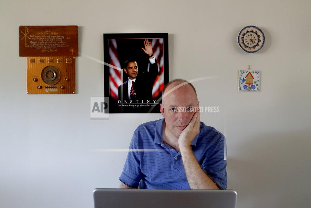 Charles Rex Arbogast Dave Adams poses for a portrait Tuesday, June 30, 2020, at the kitchen table of his parents home in St. Charles, Mich. Adams, 47, left his job as an athletics director at a suburban high school in Saginaw so that he could organize voter turnout against President Donald Trump. When he taught social studies he always made a point of telling students then that all presidents were worthy of respect. Trump was testing his beliefs, he says. “I always thought that the president should be a role model,” Adams said. “The current president is so far from it for me that it blows my mind. It’s everything I’m against.” (AP Photo/Charles Rex Arbogast)