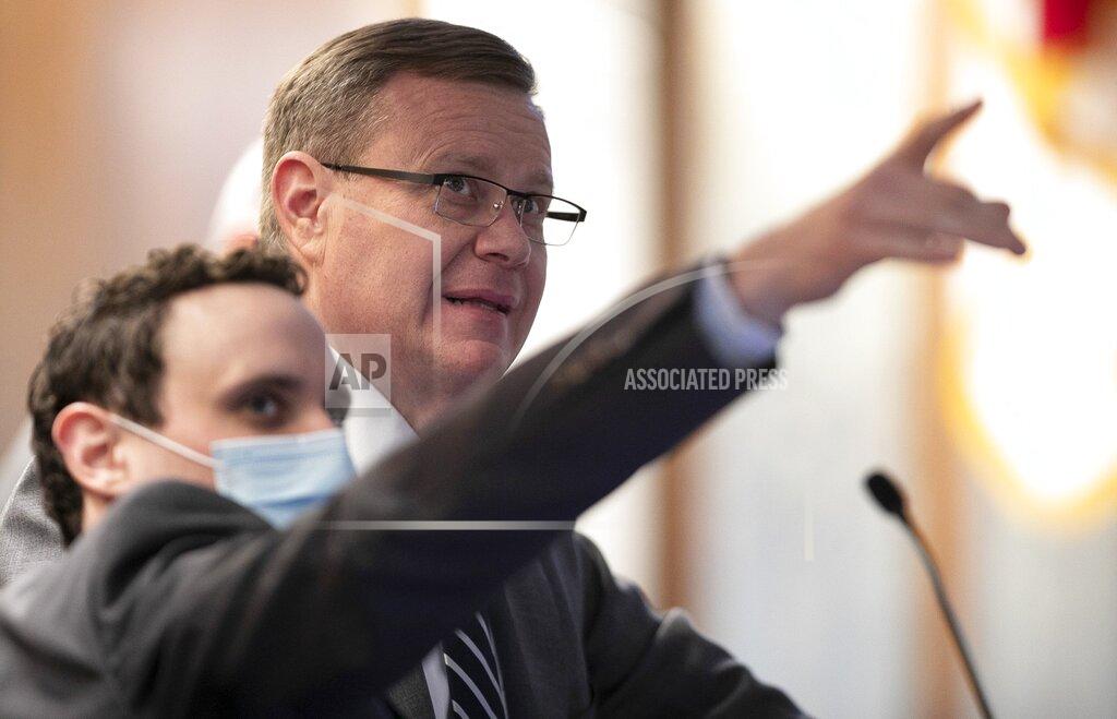 Robert Willett House Principal Clerk James White, left, talks with House Speaker Tim Moore as they observe demonstrators from #ReleaseOurMoneyNC that dropped banners from the gallery in the House chamber on Wednesday, Jan. 27, 2021, in Raleigh N.C. House Sergeants at Arms quickly removed the banners and the demonstrators from the gallery. #ReleaseOurMoneyNC were calling on lawmakers to to release the people's funds for healthcare, housing and worker's wages protections. (Robert Willett/The News & Observer via AP)