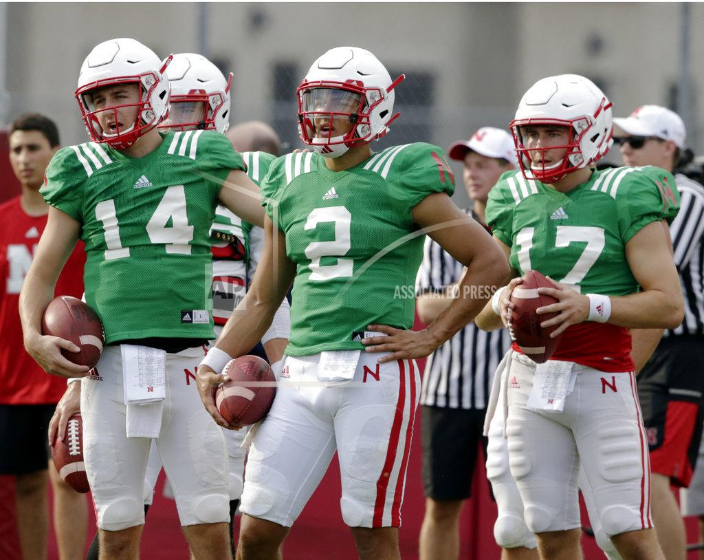 Nebraska quarterbacks Adrian Martinez (2), Tristan Gebbia (14) and Andrew Bunch (17) stand together during NCAA college football fall practice in Lincoln, Neb., Wednesday, Aug. 8, 2018. Nebraska's three-man quarterback race remains too close to call. Quarterbacks coach Mario Verduzco says Martinez, Gebbia and Bunch continue to get an equal number of snaps with the first-string offense. (AP Photo/Nati Harnik)
