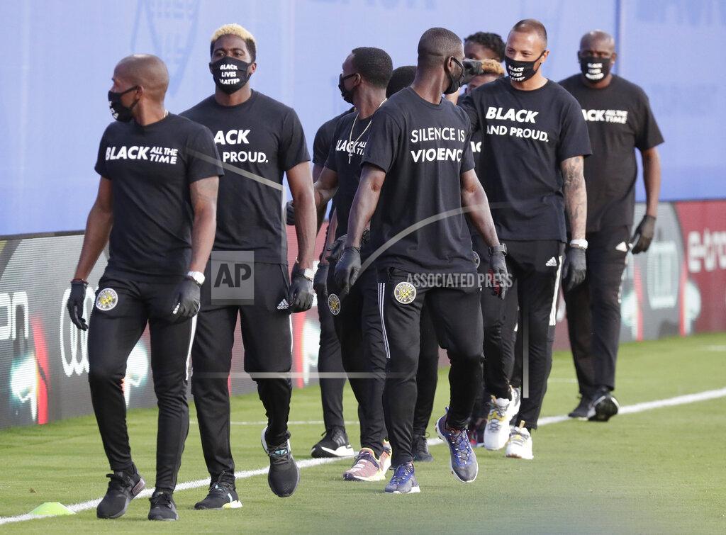 John Raoux Members of the Columbus Crew march on the field before an MLS soccer match against Orlando City on Wednesday, July 8, 2020, in Kissimmee, Fla. (AP Photo/John Raoux)