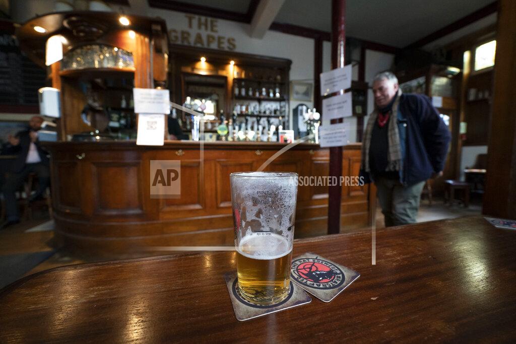 Jon Super A half-full beer glass remains on a table at the Dispensary pub in Liverpool, England, Monday Oct 12, 2020. As the first area in England slapped with strict new restrictions to curb the resurgent coronavirus that have shuttered pubs and imperiled thousands of jobs, Liverpool again feels it's being punished by policies made in Britain's capital, 180 miles (290 kilometers) to the south. (AP Photo/Jon Super)