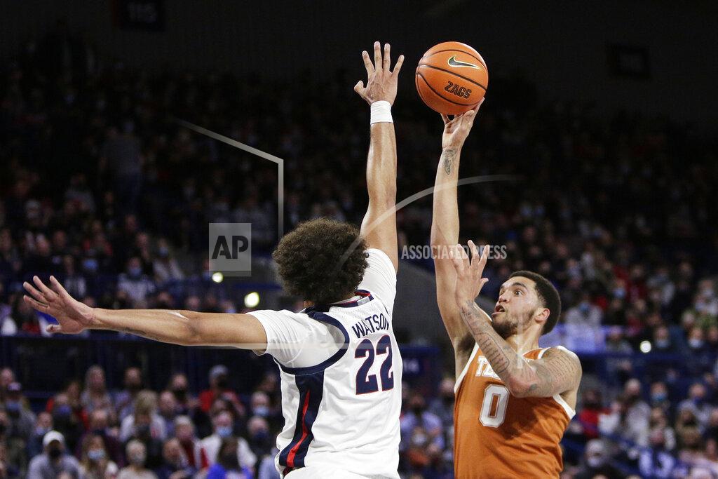Young Kwak Texas forward Timmy Allen (0) shoots while pressured by Gonzaga forward Anton Watson (22) during the first half of an NCAA college basketball game, Saturday, Nov. 13, 2021, in Spokane, Wash. (AP Photo/Young Kwak)