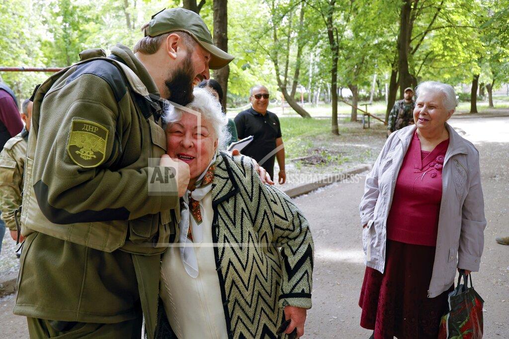 Alexei Alexandrov A serviceman of Donetsk People's Republic militia embraces a local woman in Svitlodarsk, in territory under the government of the Donetsk People's Republic, eastern Ukraine, Thursday, May 26, 2022. Svetlodarsk came under the control of the forces of the people's republics, as a result of the offensive of their units and with the support of Russian troops. (AP Photo/Alexei Alexandrov)