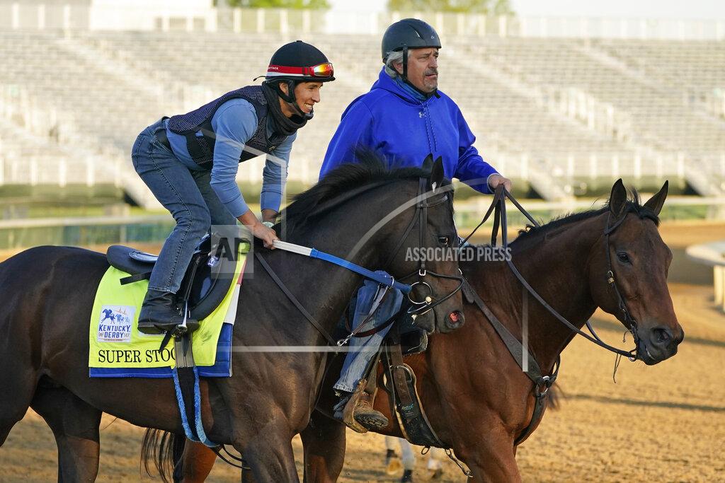 Charlie Riedel Trainer Steve Asmussen, right, leads Kentucky Derby hopeful Super Stock on the track at Churchill Downs Tuesday, April 27, 2021, in Louisville, Ky. Asmussen's parents co-own the horse along with a partner. (AP Photo/Charlie Riedel)