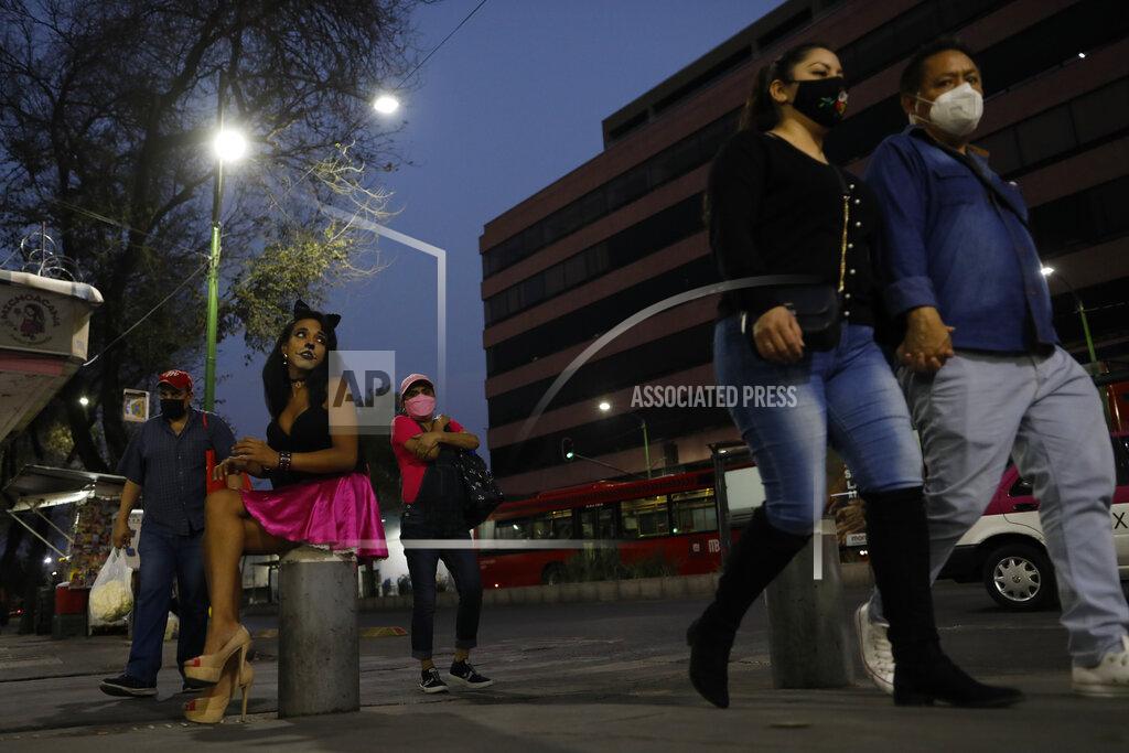 Rebecca Blackwell Sex worker Geraldine wearing cat make-up sits on her usual corner as she waits for clients outside the Revolution subway station, in Mexico City, Saturday, March 13, 2021. Geraldine, 30, a sex worker since age 15, says many of her regular clients have stopped coming amid the coronavirus pandemic and that seeing new clients presents new health and security risks. She is most concerned about the risk of bringing COVID-19 home to her partner, who has diabetes. (AP Photo/Rebecca Blackwell)