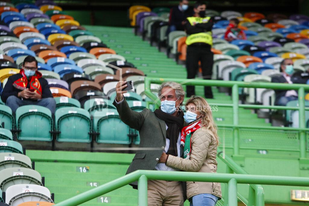 Armando Franca A couple wearing face masks take a selfie on the stands during a soccer match between Portugal and Sweden at the Jose Alvalade stadium in Lisbon, Portugal, Wednesday, Oct. 14, 2020. Five thousand spectators were allowed on the stands but starting Wednesday at midnight, and for the upcoming two weeks, a maximum of five people will be allowed together either indoors or outdoors in public spaces and establishments such as restaurants due to a steady increase in cases of COVID-19 in the past weeks. (AP Photo/Armando Franca)