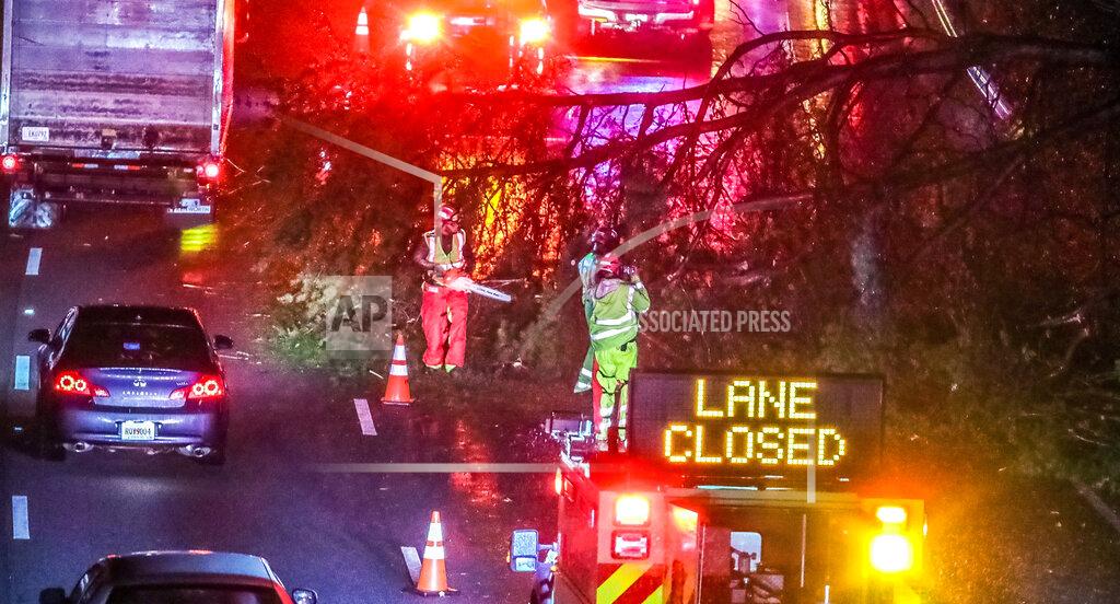 John Spink Authorities work to clear a fallen tree that is blocking a lane on I-20 at Langhorn Street in Atlanta on Thursday morning, Oct. 29, 2020. Tropical Storm Zeta sped across the Southeast on Thursday, leaving a trail of damage and more than 2 million homes and businesses in the dark in Atlanta. (John Spink/Atlanta Journal-Constitution via AP)
