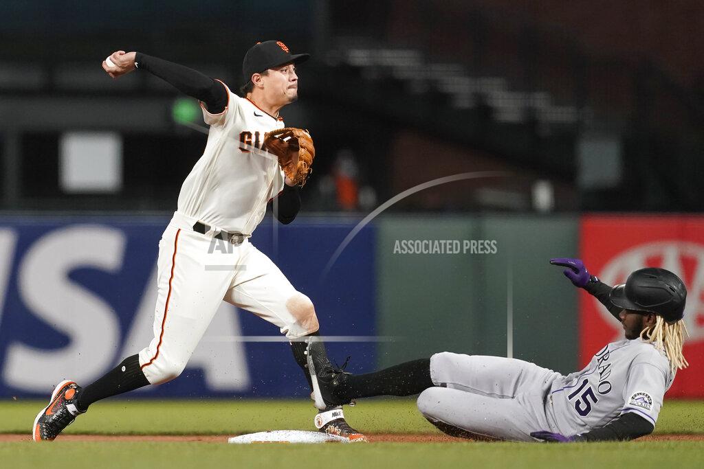 Jeff Chiu San Francisco Giants second baseman Wilmer Flores, left, throws to first base after forcing out Colorado Rockies' Raimel Tapia, right, at second base during the sixth inning of a baseball game in San Francisco, Monday, April 26, 2021. (AP Photo/Jeff Chiu)