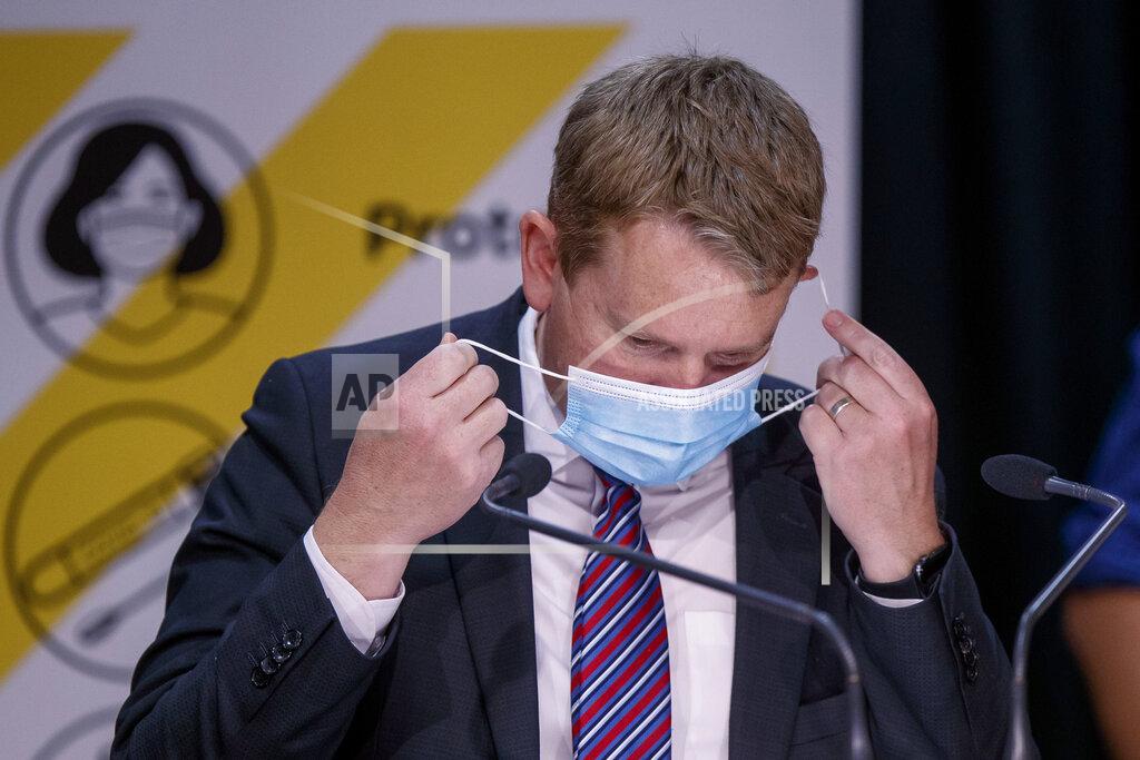 Robert Kitchin New Zealand's COVID-19 Response Minister Chris Hipkins takes his mask off at a press conference in Wellington, New Zealand, Thursday, Oct. 28, 2021. Hipkins said that from next month, most people arriving in New Zealand would need to spend seven days in a quarantine hotel run by the military, half the previous requirement. (Robert Kitchin/Pool Photo via AP)