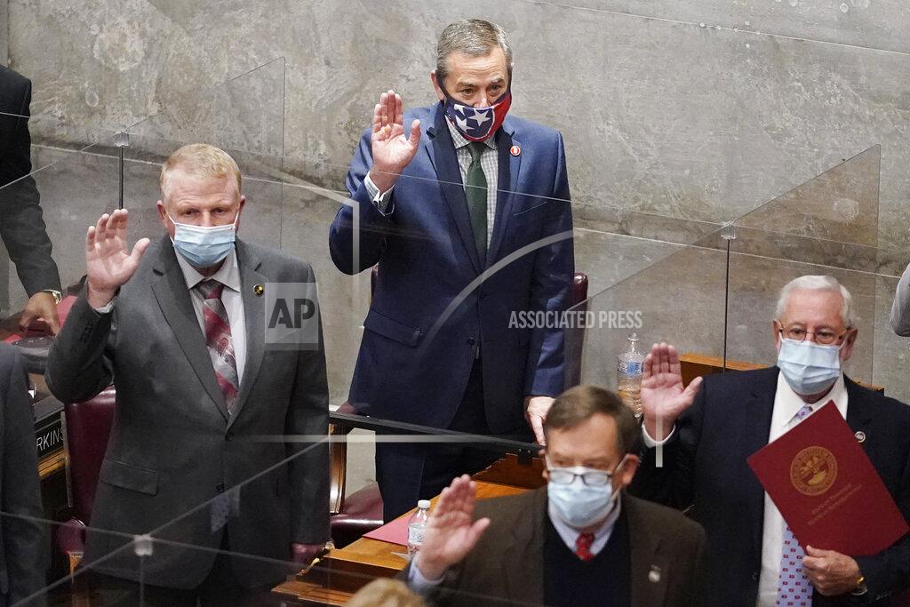Rep. Glen Casada, R-Franklin, top center, is sworn in with other members on the first day of the legislative session Tuesday, Jan. 12, 2021, in Nashville, Tenn. Tennessee lawmakers gathered to start their annual session Tuesday in Nashville amid a pandemic and an FBI probe that drew searches of multiple legislative offices by federal agents last week. Those lawmakers include former House Speaker Casada, Rep. Todd Warner and Rep. Robin Smith. (AP Photo/Mark Humphrey)