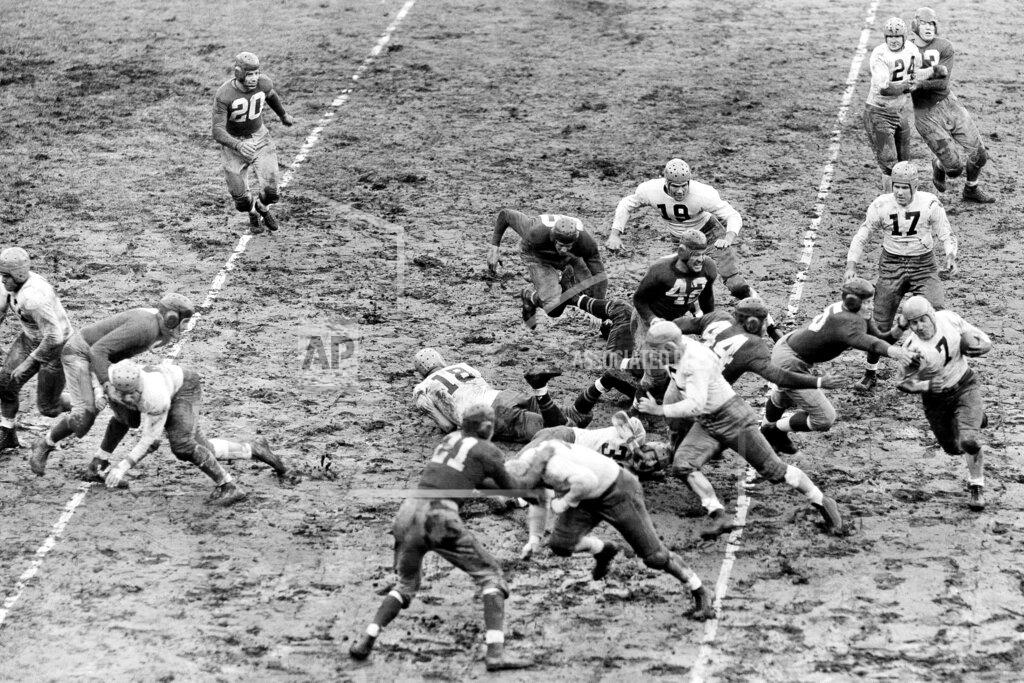 Uncredited FILE - In this Nov. 20, 1938, file photo, Green Bay Packers Ed Jankowski (7), far right, runs after taking the handoff from Cecil Isbell (17) on a reverse as New York Giants Ken Lunday (5) reaches out on an attempted tackle, at the Polo Grounds in New York. The Giants defeated the Packers 15-3. Jankowski is following teammate and blocker Henry Bruder (5). The Giants player in the foreground is Jim Lee Howell (21). The Packers won four titles in the 1930s, including the first two of the decade _ capping a run of three straight _ when they finished with the league's best record. Green Bay also won in 1936 and '39. (AP Photo/File)
