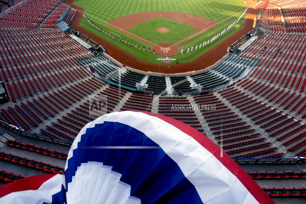 Jeff Roberson Bunting blows in the breeze over empty seats in this general view of Busch Stadium as members of the St. Louis Cardinals, right, and Pittsburgh Pirates line up to be introduced before the start of an opening day baseball game for the teams Friday, July 24, 2020, in St. Louis. (AP Photo/Jeff Roberson)