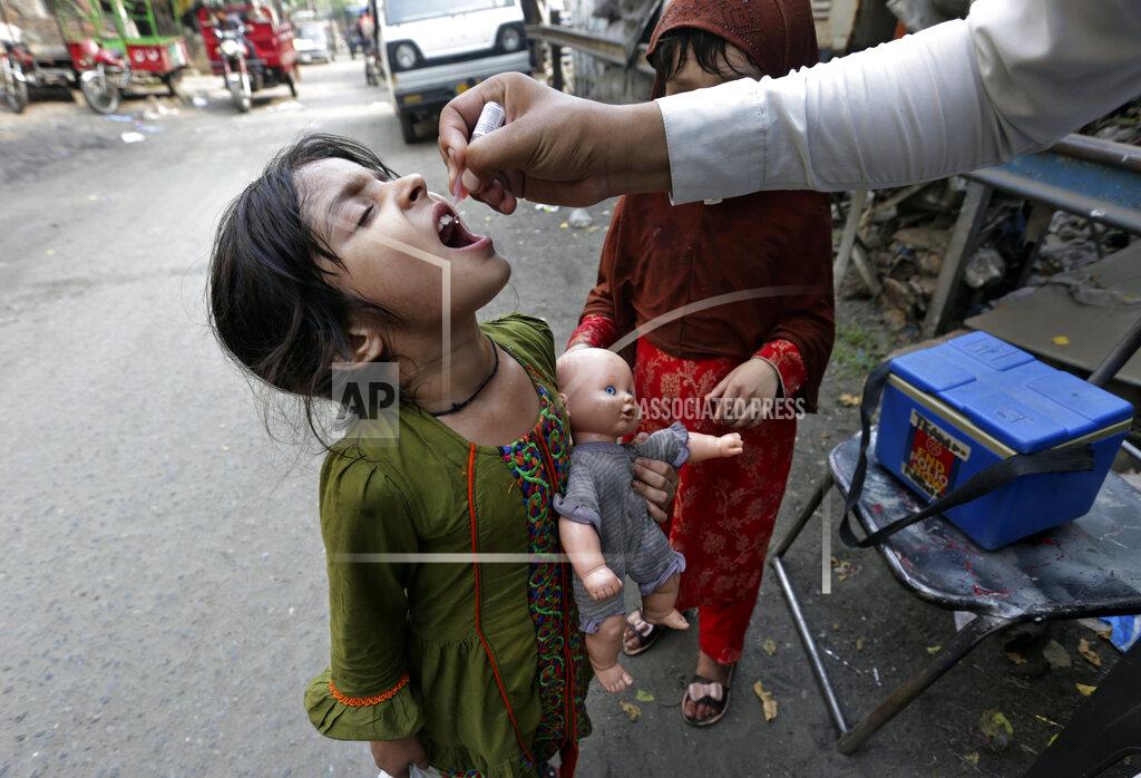 K.M. Chaudary A health worker gives a polio vaccine to a girl on a street in Lahore, Pakistan, Monday, June 27, 2022. Pakistan launched a new anti-polio drive on Monday, with the goal to vaccinate a million children across Pakistan. (AP Photo/K.M. Chaudary)
