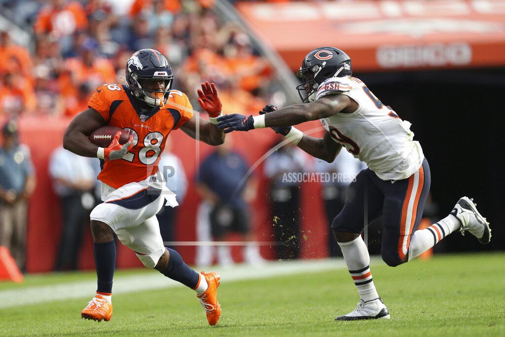 Denver Broncos running back Royce Freeman (28) tries to stiff-arm Chicago Bears inside linebacker Danny Trevathan (59) as Freeman carries the ball in an NFL game against the Chicago Bears, Sunday Sept. 15, 2019, in Denver. The Bears defeated the Broncos 16-14. (Margaret Bowles via AP)