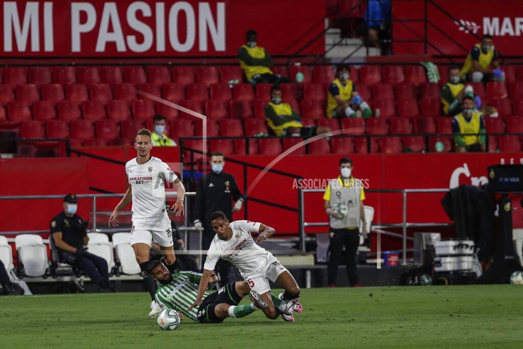 Str A Betis player, center, duels for the ball against Sevilla players during their Spanish La Liga soccer match in Seville, Spain, Thursday, June 11, 2020. With virtual crowds, daily matches and lots of testing for the coronavirus, soccer is coming back to Spain. The Spanish league resumes this week more than three months after it was suspended because of the pandemic, becoming the second top league to restart in Europe. The Bundesliga was first. The Premier League and the Italian league should be next in the coming weeks. (AP Photo)