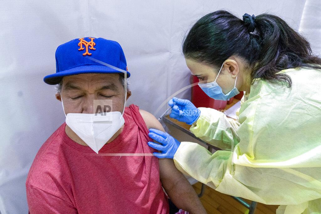 Mary Altaffer Registered Nurse Rita Alba, right, gives Gustavo Hernandez the first dose of coronavirus vaccine at a pop-up COVID-19 vaccination site at the Bronx River Addition NYCHA complex, Sunday, Jan. 31, 2021, in the Bronx borough of New York. From elderly Cuban Americans in Florida to farmworkers in California, Latinos face daunting barriers like fear, language and a lack of education and access as the COVID-19 vaccines roll out, creating risks for public health as the virus mutates and spreads. (AP Photo/Mary Altaffer)