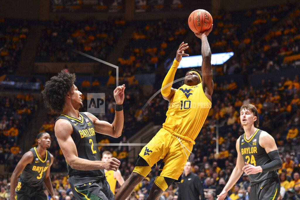 William Wotring West Virginia guard Malik Curry (10) shoots while being guarded by Baylor guard Kendall Brown (2) during the first half of an NCAA college basketball game in Morgantown, W.Va., Tuesday, Jan. 18, 2022. (William Wotring)