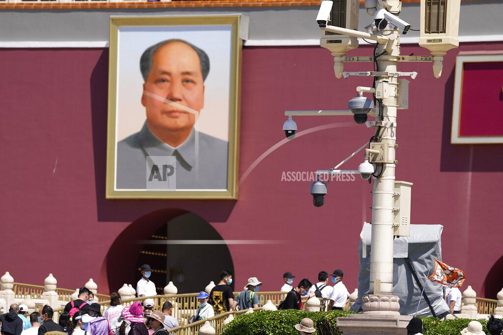 Ng Han Guan With surveillance cameras seen on a pole, plainclothes security personnel watch as tourists visits Tiananmen Gate on the 32nd anniversary of a deadly crackdown on pro-democracy protests in Beijing on Friday, June 4, 2021. Commemorations of the June 4, 1989 crackdown on student-led pro-democracy protests centered on Beijing's Tiananmen Square were especially muted Friday amid pandemic control restrictions and increasing political repression. (AP Photo/Ng Han Guan)