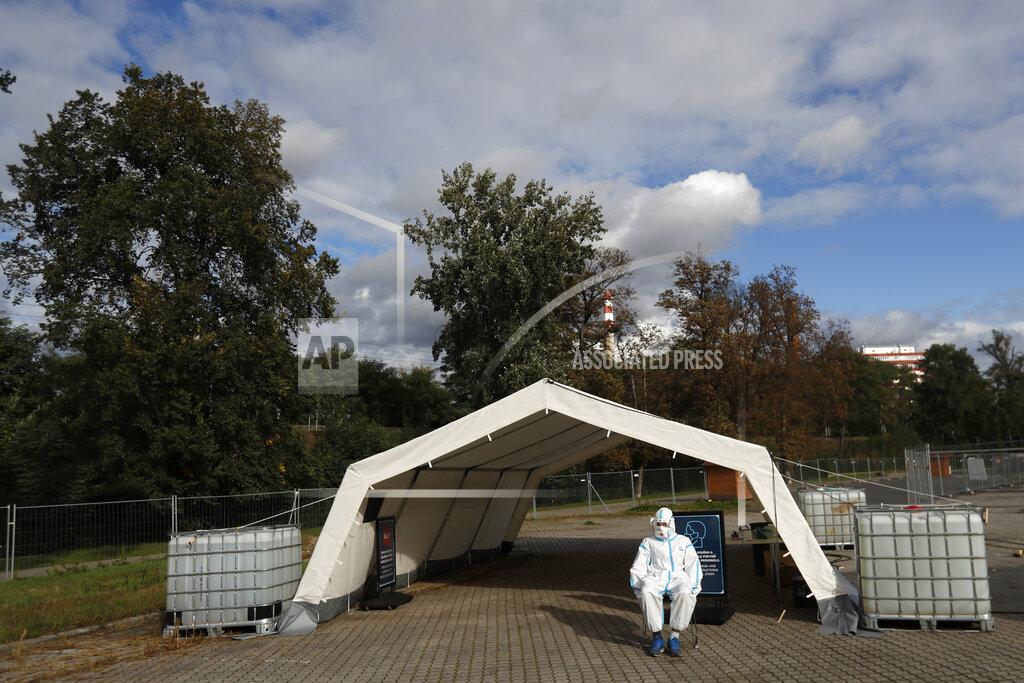 Petr David Josek A health care worker in full protective gear, waits to conduct a COVID-19 test at a drive-in sampling station in Prague, Czech Republic, Wednesday, Oct. 7, 2020. Coronavirus infections in the Czech Republic hit a new record high, surpassing 4,000 cases in one day for the first time. (AP Photo/Petr David Josek)