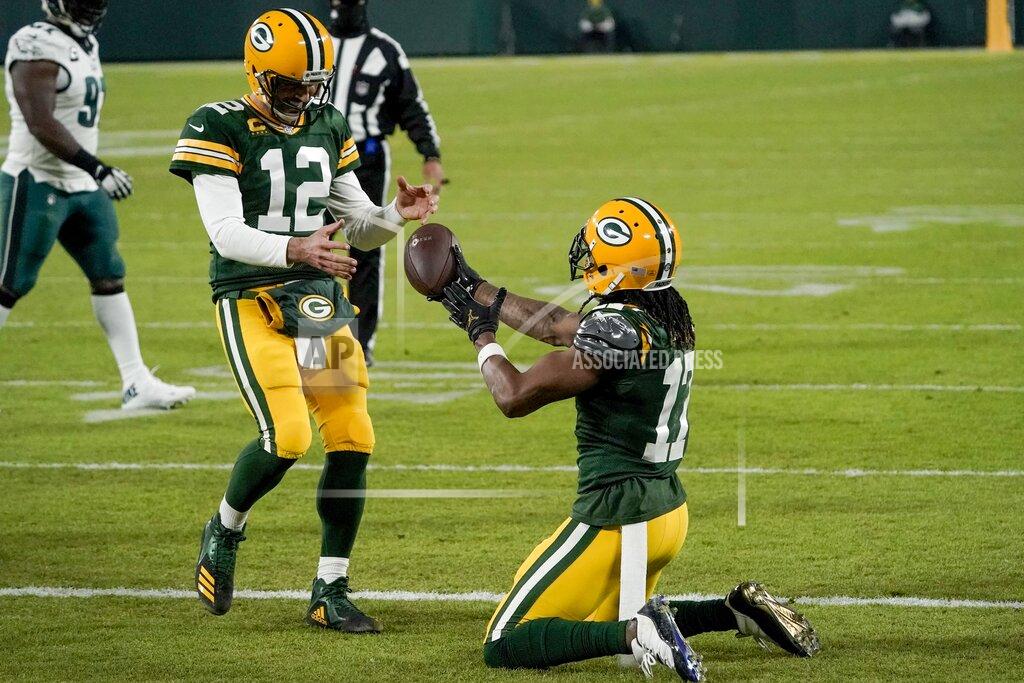 Morry Gash Green Bay Packers' Davante Adams hands the ball to quarterback Aaron Rodgers after catching a touchdown pass during the second half of an NFL football game against the Philadelphia Eagles Sunday, Dec. 6, 2020, in Green Bay, Wis. The pass was Rodgers' 400th career touchdown pass. (AP Photo/Morry Gash)