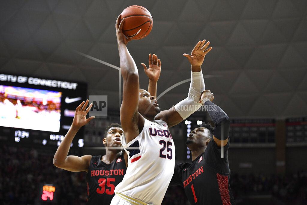 Jessica Hill Connecticut's Josh Carlton (25) goes up for a basket against Houston's Fabian White Jr. (35) and Chris Harris Jr. (1) in the first half of an NCAA college basketball game, Thursday, March 5, 2020, in Storrs, Conn. (AP Photo/Jessica Hill)