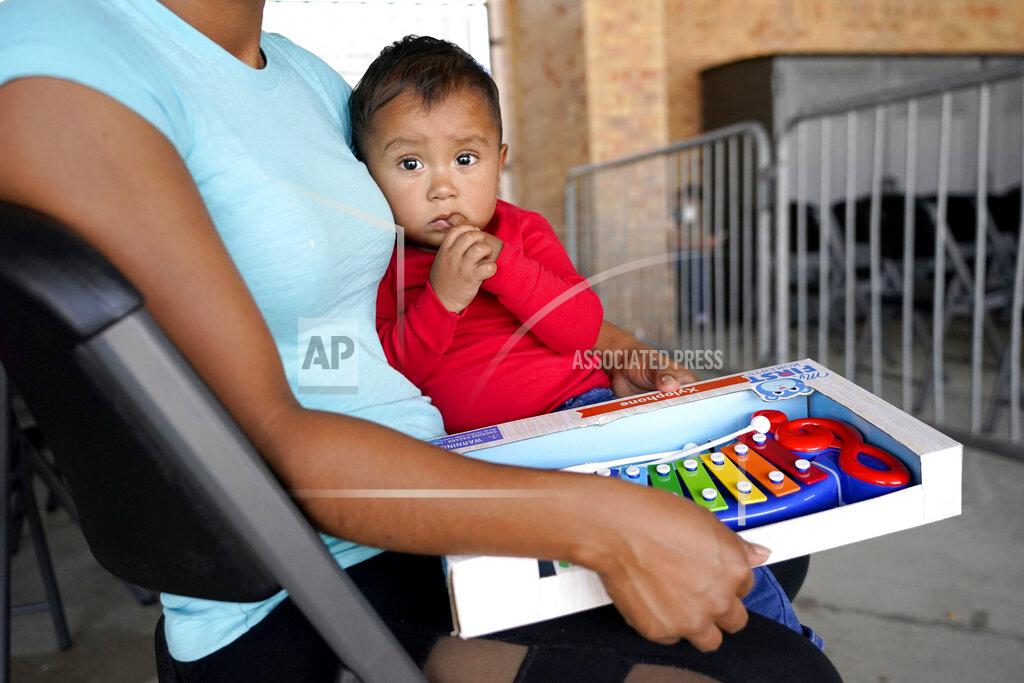Julio Cortez Fifteen-month-old Matias Marin sits on the lap of his mother Naciel Marin, 23, of Nicaragua, as they wait for travel instructions to Wisconsin at a bus station in Brownsville, Texas, Wednesday, March 17, 2021. The Marin family left their native Nicaragua a month and half ago to seek asylum in the U.S. During their trek, Matias has become ill with a cold that his mother said still lingers. A surge of migrants on the Southwest border has the Biden administration on the defensive. The head of Homeland Security acknowledged the severity of the problem Tuesday but insisted it's under control and said he won't revive a Trump-era practice of immediately expelling teens and children. (AP Photo/Julio Cortez)